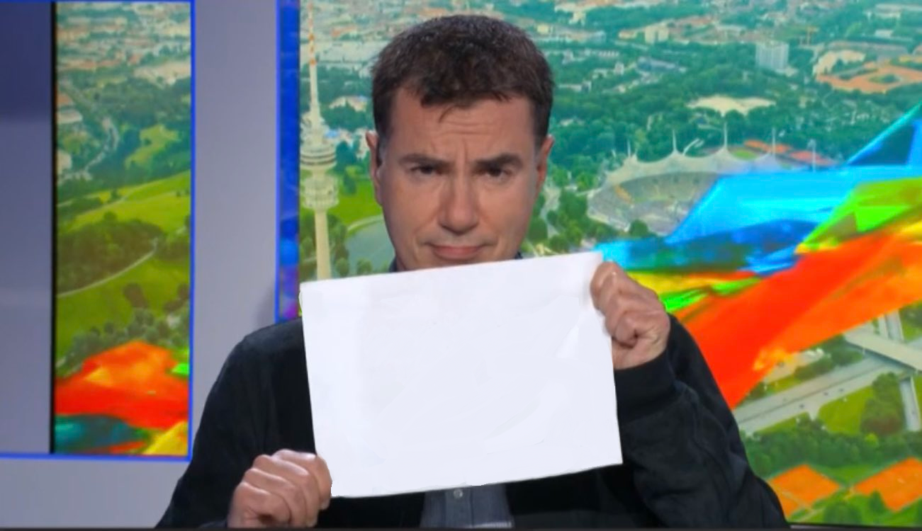 Laurent Luyat, circonspect, montrant un message écrit sur une feuille blanche